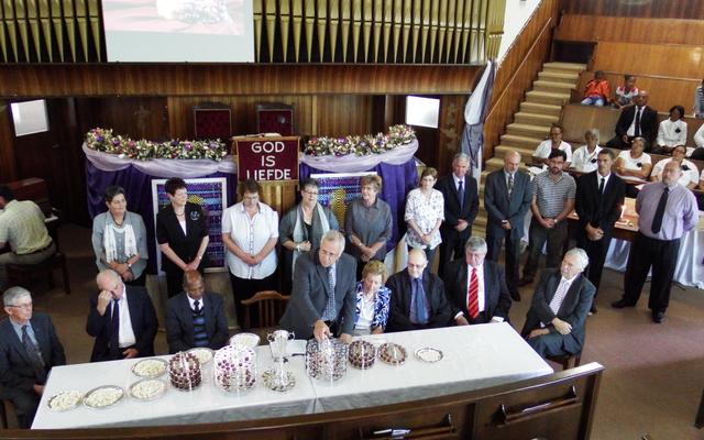 Die bediening van die Heilige Nagmaal deur ds Dirk van Dyk (middel) met al 7 streeksverteenwoordigers by die Nagmaalstafel